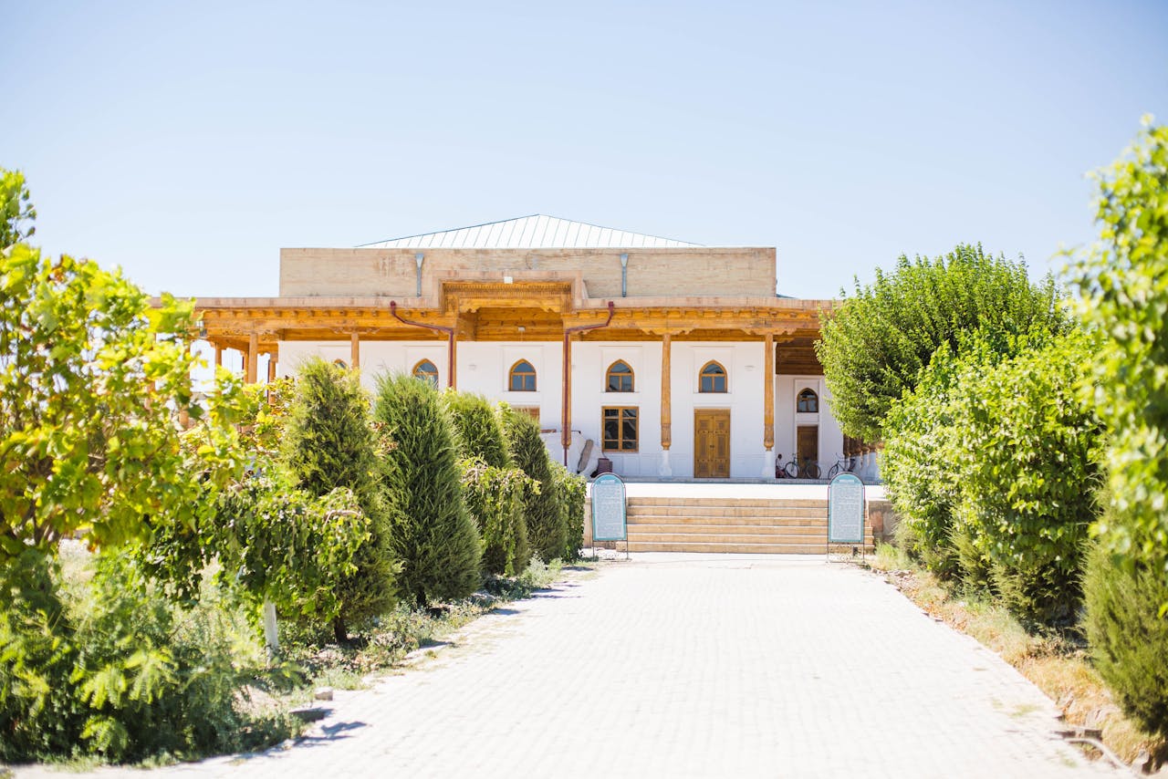 services-05 Explore the charming exterior of a traditional Uzbek house in Gijduvon surrounded by greenery.