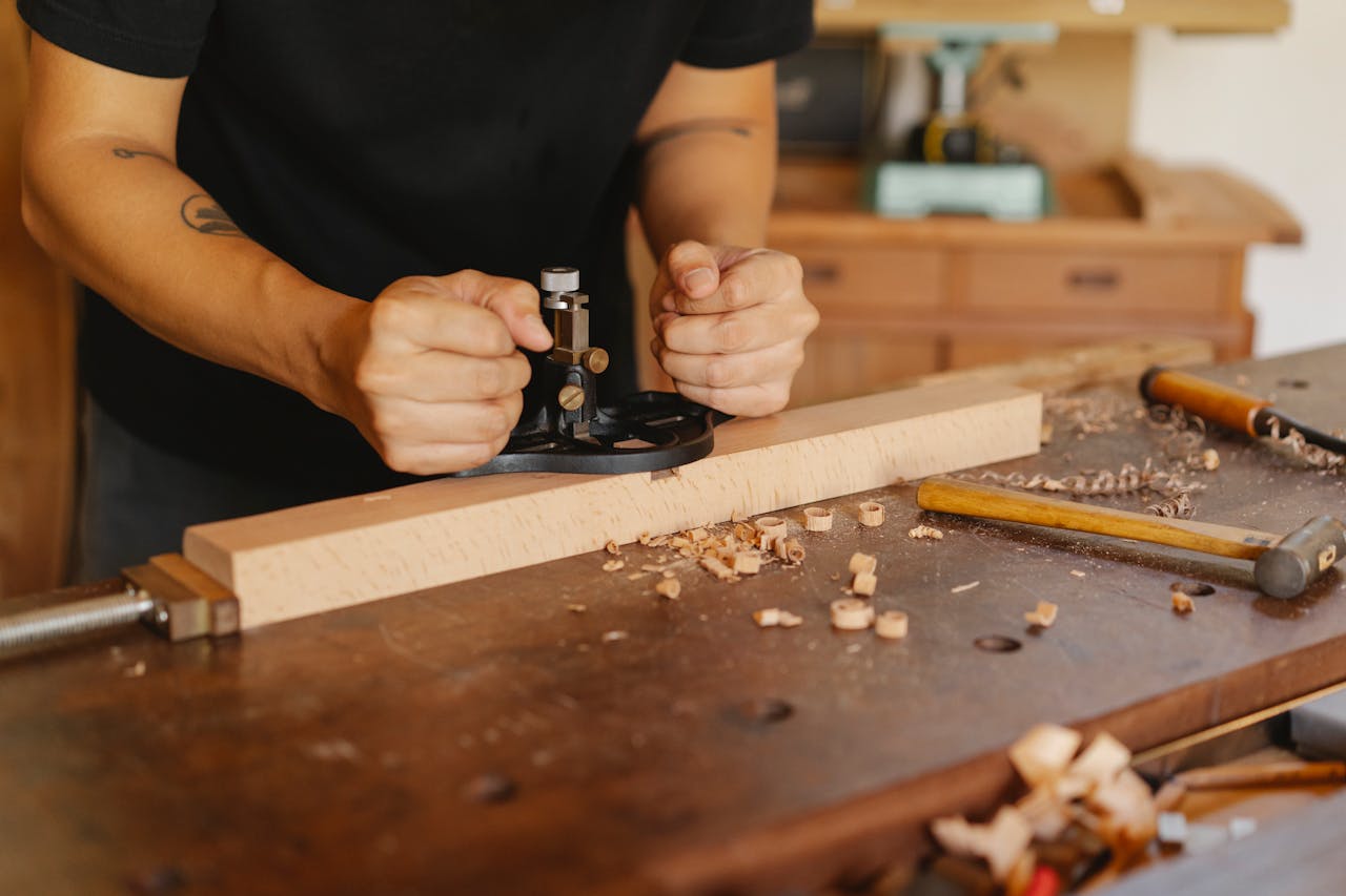 get-in-touch A skilled woodworker carefully crafting a wooden piece with hand tools in a workshop setting.